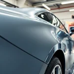 Apply paint protection film near me on a luxury car in a professional garage setting.